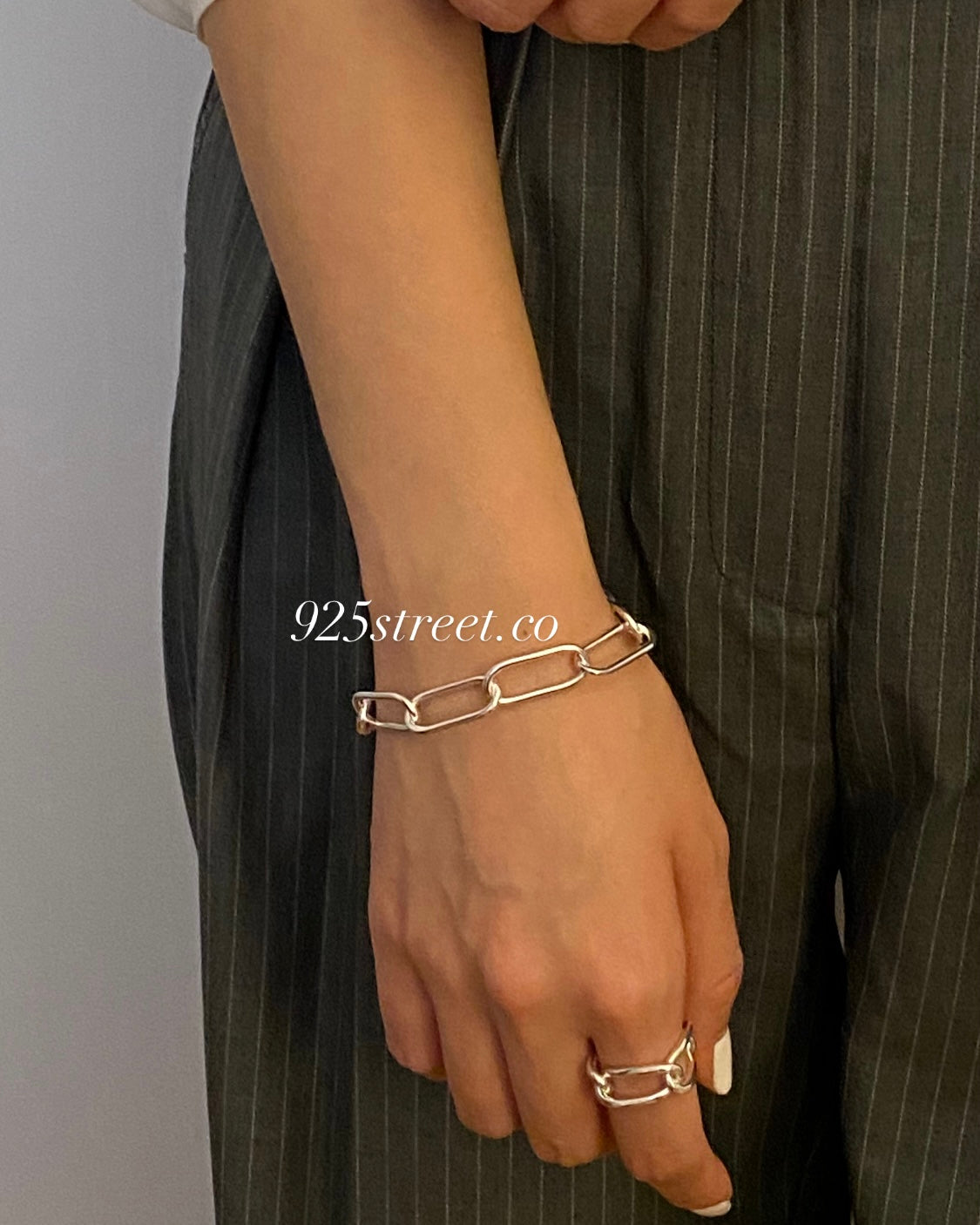 Woman wearing trendy sterling silver paperclip bracelet for everyday style