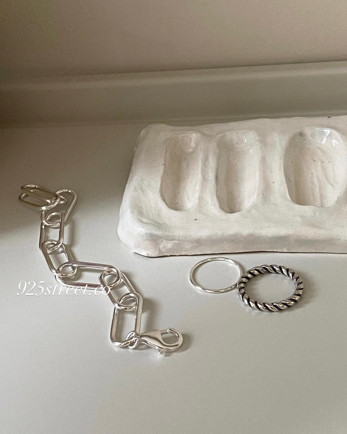 Close up of polished S925 sterling silver paperclip links and lobster clasp