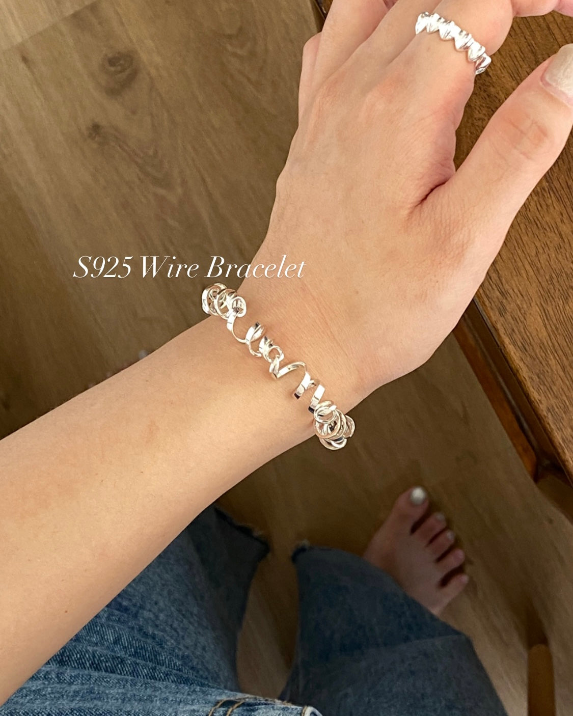 Woman wearing contemporary sterling silver twisted ribbon link bracelet from 925Street