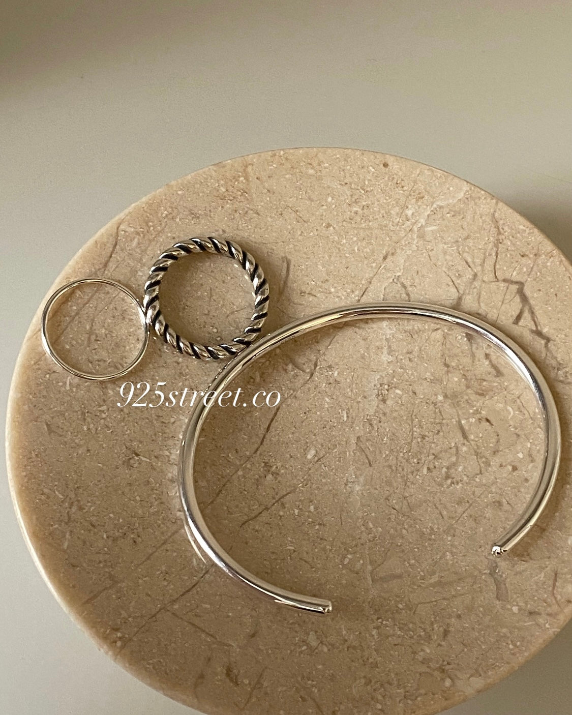 Sterling Silver Sleek Cuff Bangle, highly polished, on a light grey background