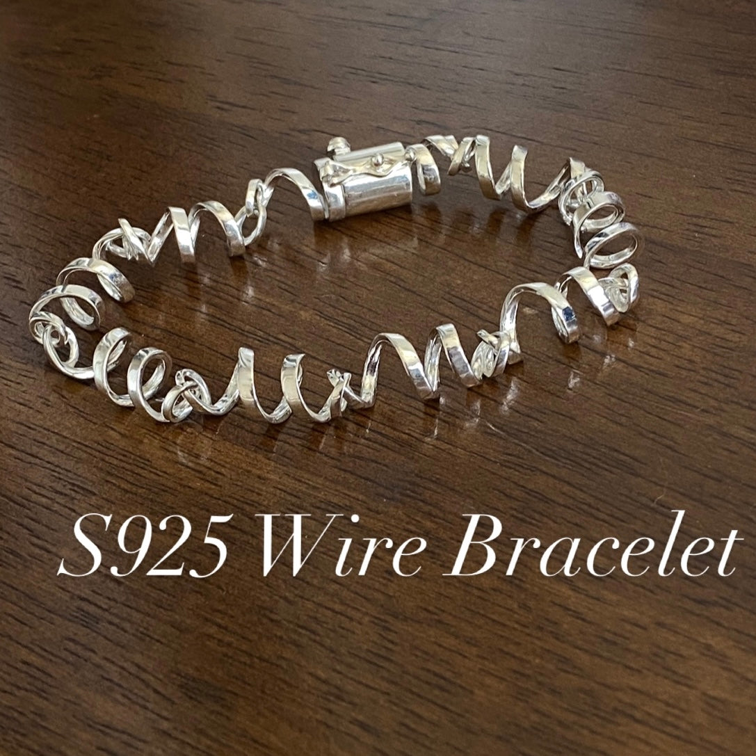 Sterling Silver Twisted Ribbon Wire Bracelet with box clasp on wood background
